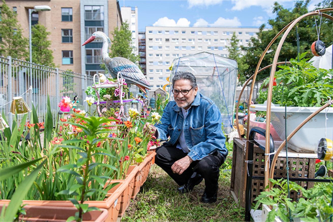 Sanctuary resident inspecting flowers grown at Anderston allotments